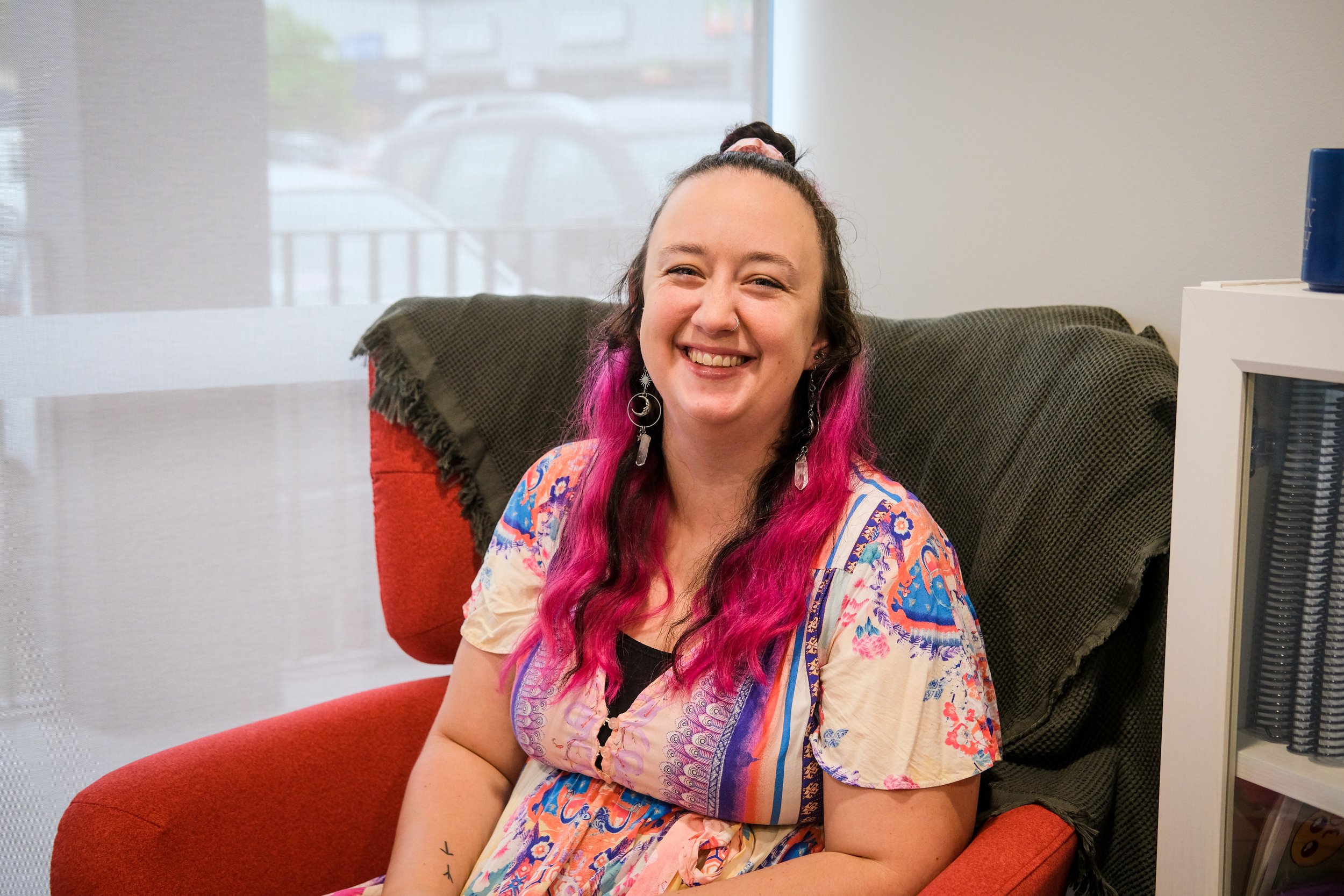 Rachel (Principal Social Worker) sitting in a red chair smiling